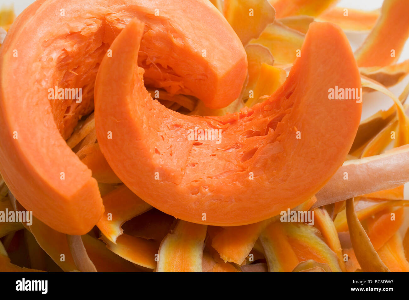 Wedges of pumpkin on pumpkin peelings - Stock Photo