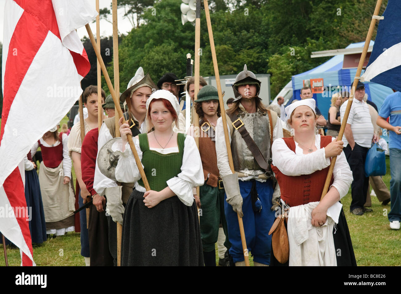 Troope of actors dressed as medieval footsoldiers with female flag bearers Stock Photo