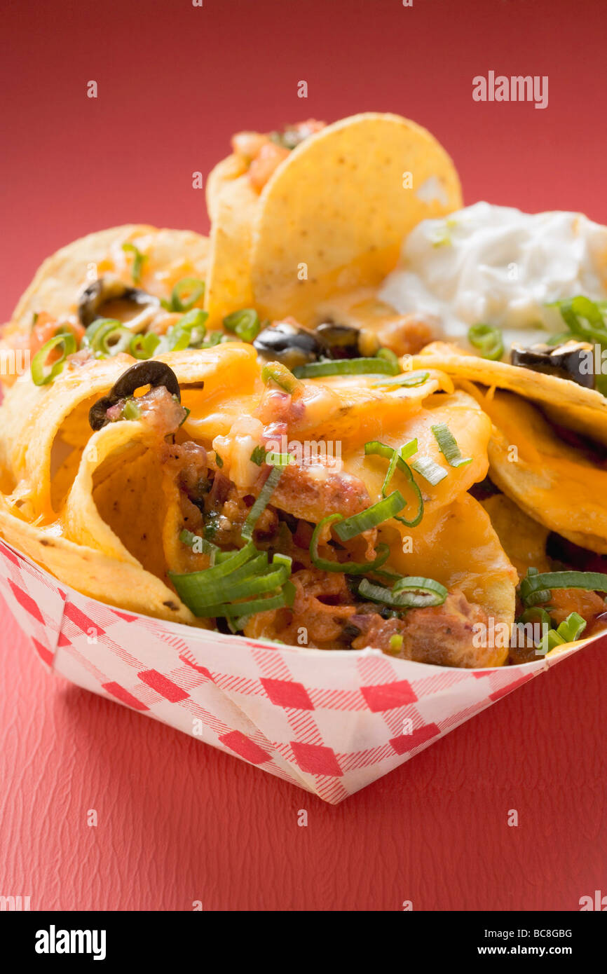 Tortilla chips with melted cheese in cardboard container Stock Photo