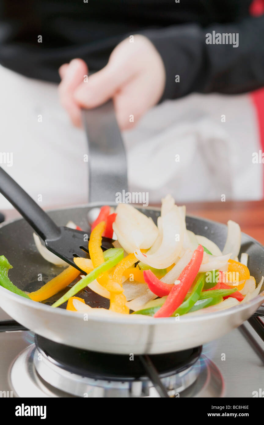 Sautéing vegetables in frying pan - Stock Photo
