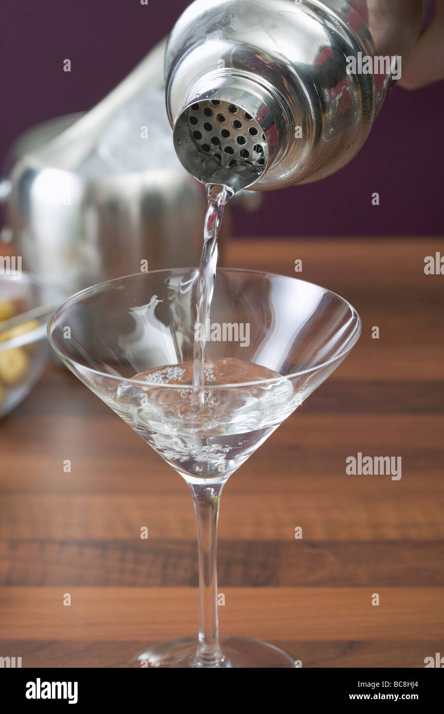 Pouring Martini out of cocktail shaker into glass Stock Photo Alamy