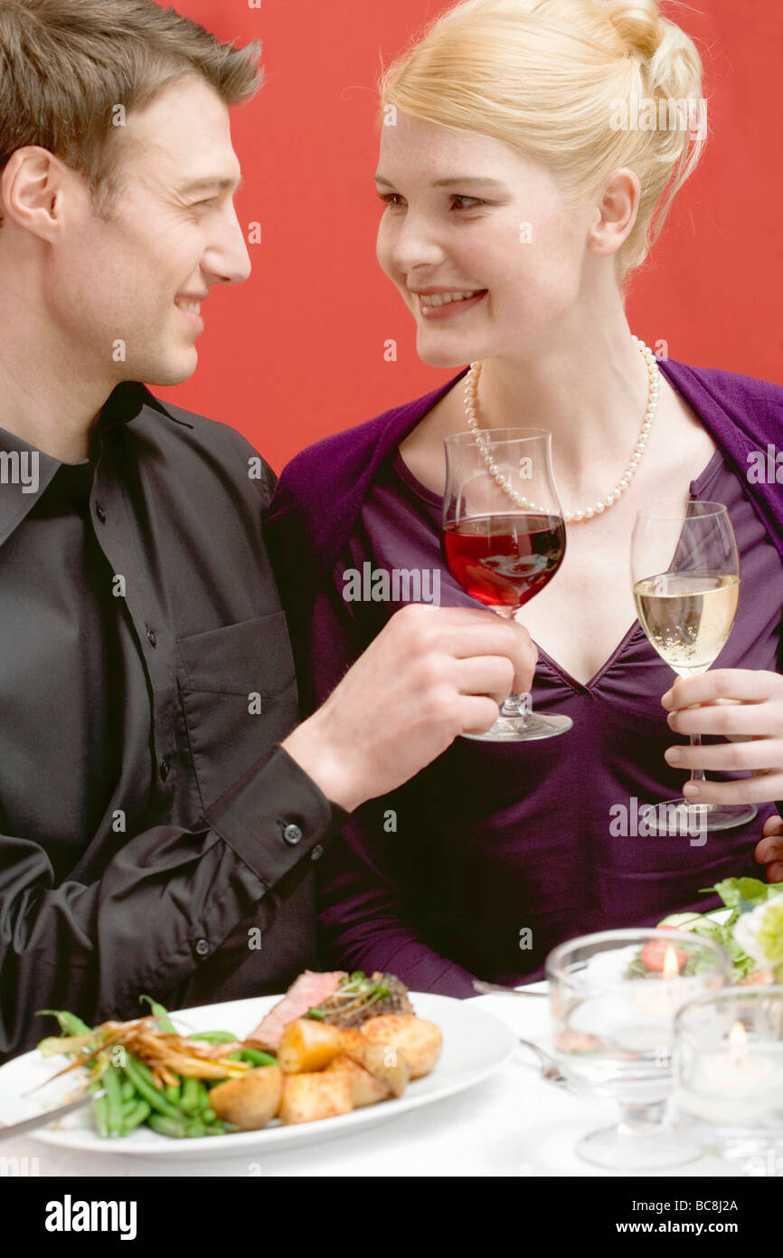 Elegant couple raising glasses of wine Stock Photo - Alamy