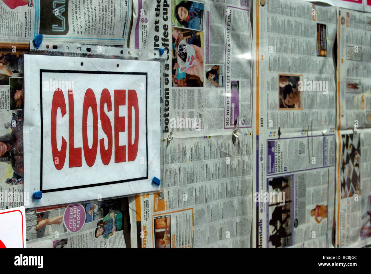 closed sign on a closed-down shop in hounslow high street, england, its window lined by old newspapers Stock Photo
