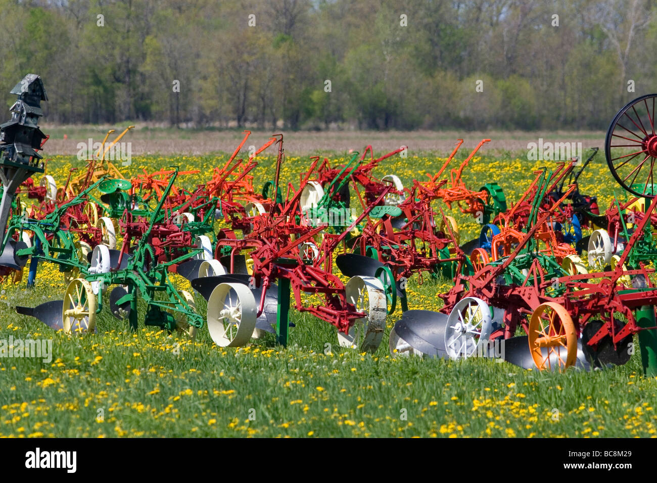 Colorfully painted antique plows on display at a farm near Corunna