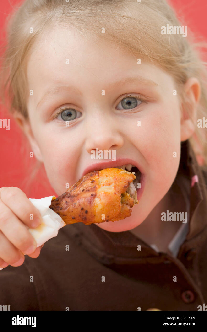 Little girl eating chicken drumstick Stock Photo Alamy