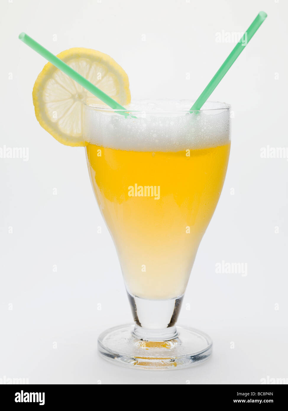 Glass of shandy with slice of lemon and straws (UK) - Stock Photo