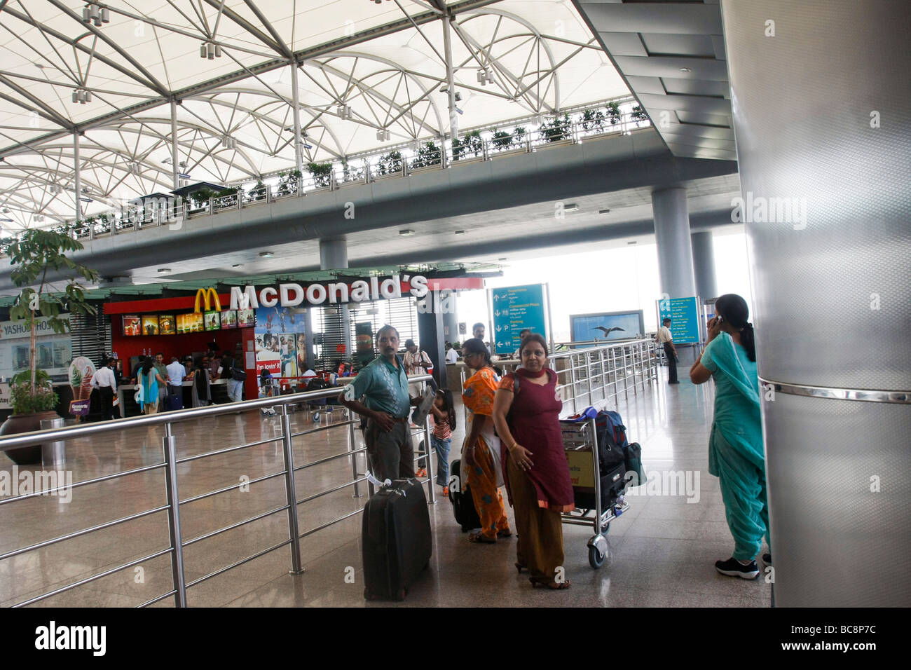 Passangers and a McDonalds restaurant outside the arrival terminal at Rajiv Gandhi international airport in Hyderabad in India Stock Photo