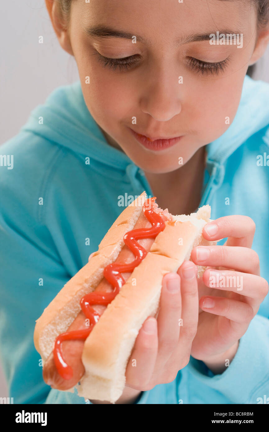 Little girl eating hot dog with ketchup Stock Photo Alamy