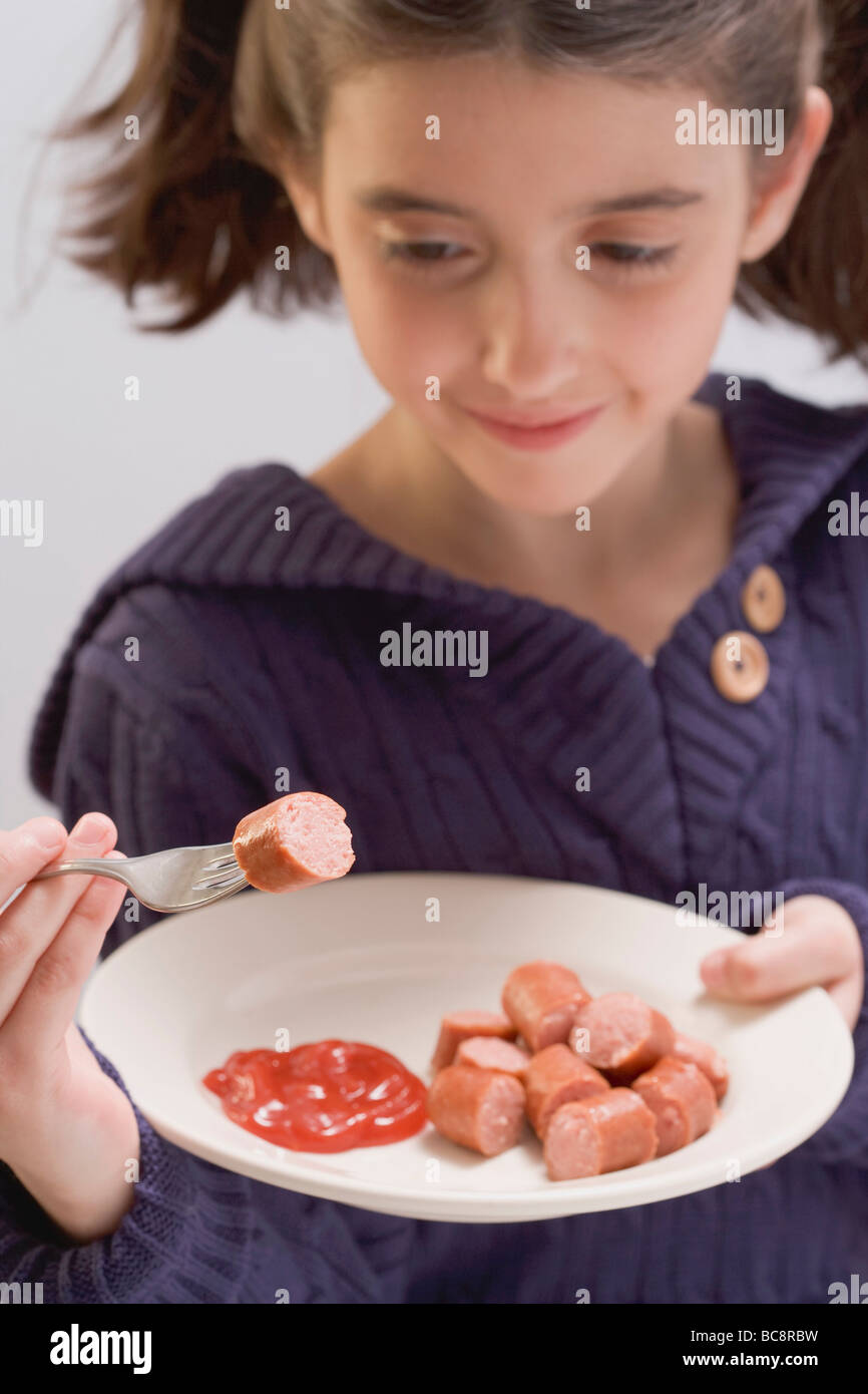 Little girl eating frankfurters with ketchup Stock Photo Alamy