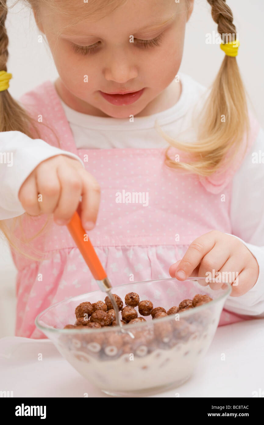 Little girl eating cereal with milk Stock Photo Alamy