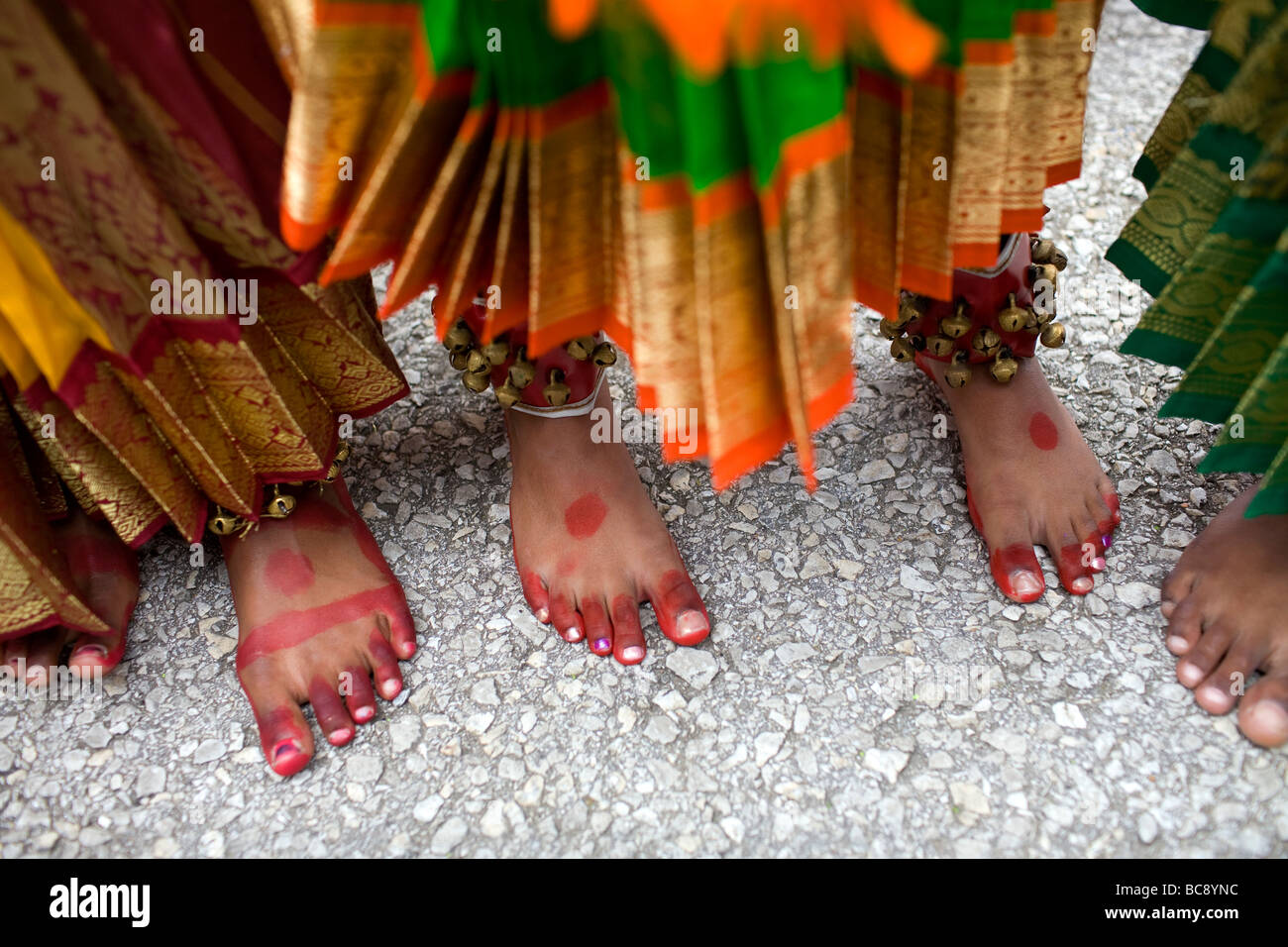 The painted feet of three East Indian or Hindu girls waiting to perform at a festival. Stock Photo