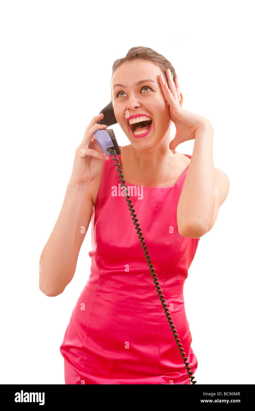 Woman in pink affectionately spaking over telephone Stock Photo