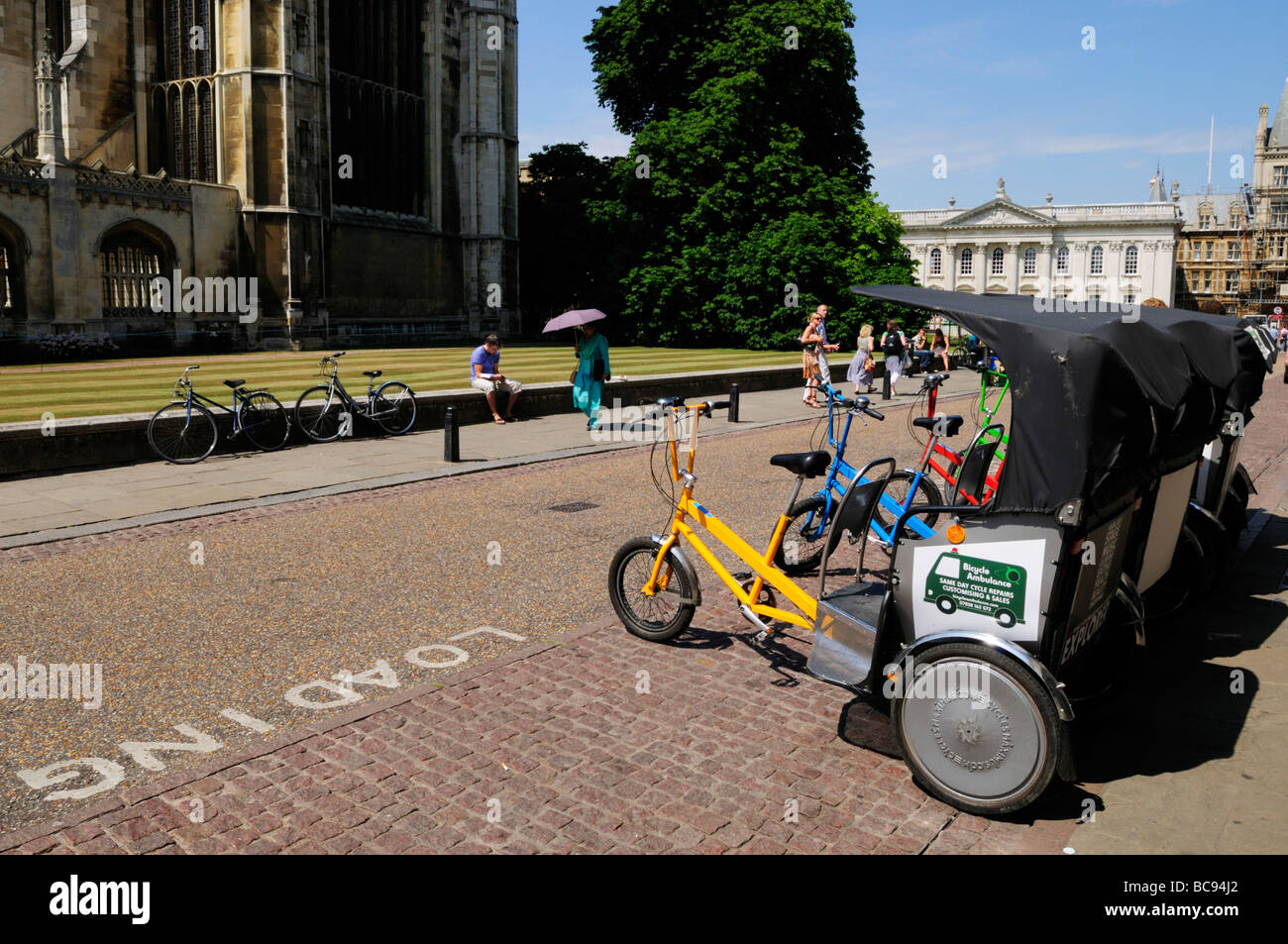 A rank of pedicabs cycle rickshaws available for hire by tourists outside Kings College, Cambridge England Uk Stock Photo