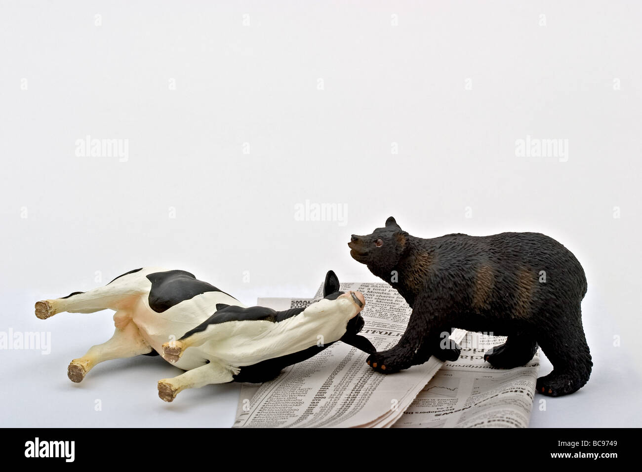 Bear standing by a bull lying on it's side upon a stock market listing. Stock Photo