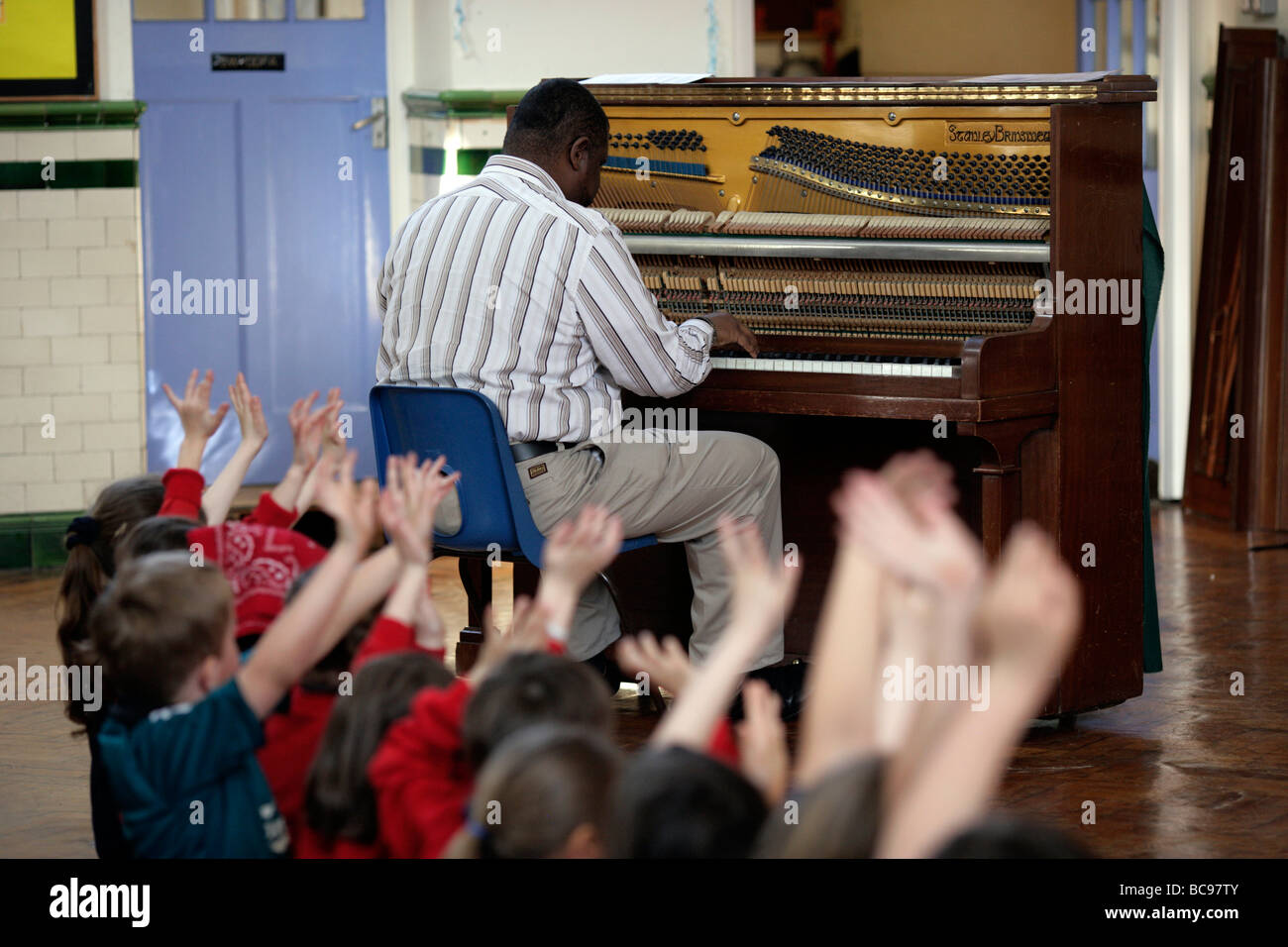 Pianist or teacher playing in a classroom Stock Photo