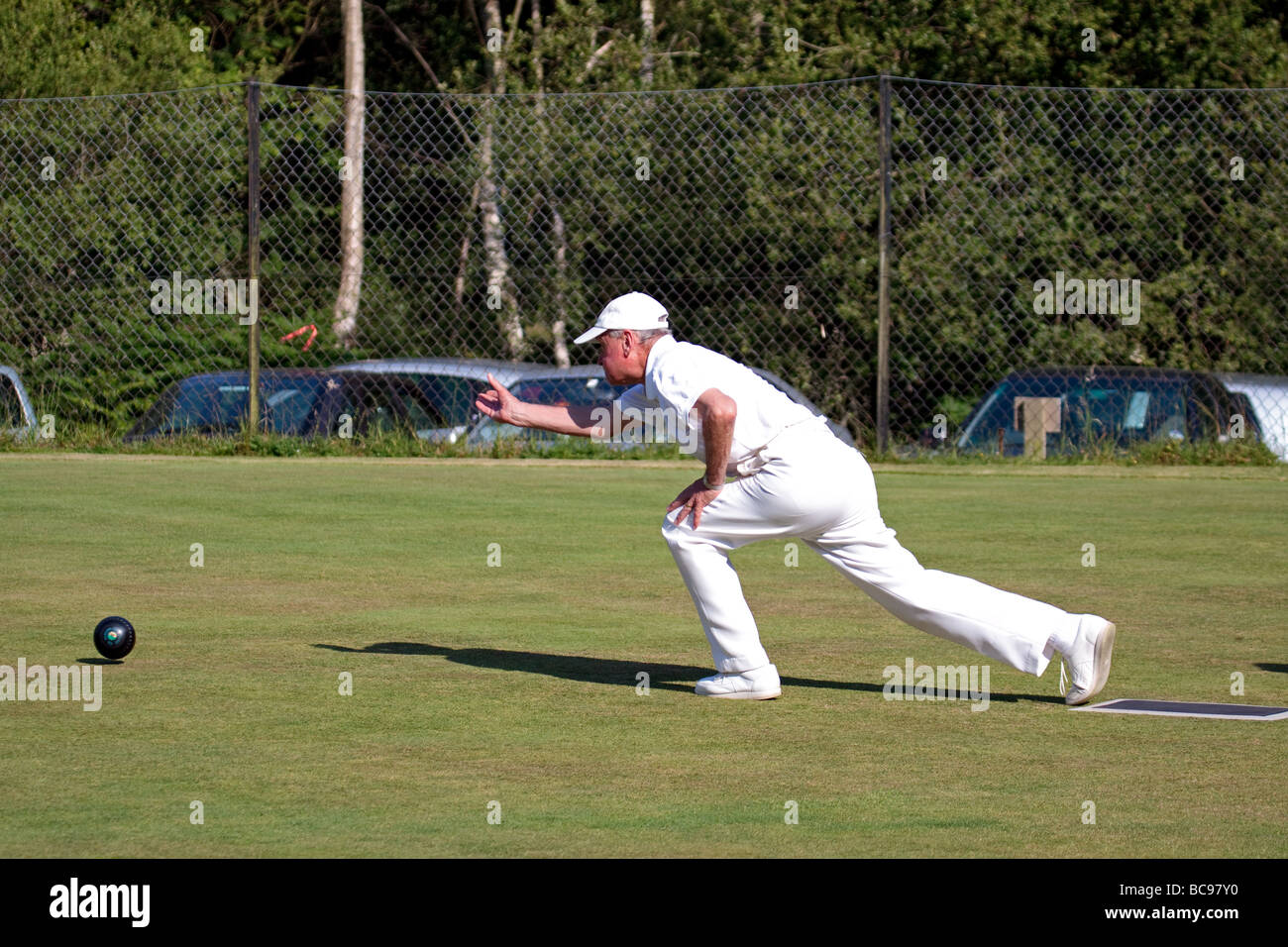Man bowling a wood at a bowls match at Colemans Hatch East Sussex Stock Photo