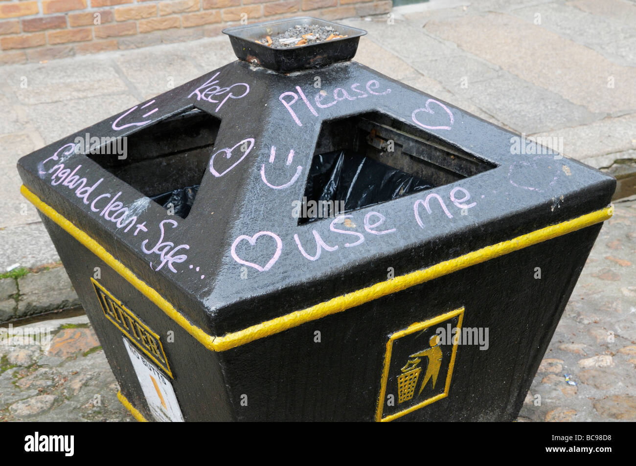 Public litter bin covered in graffiti message Stock Photo