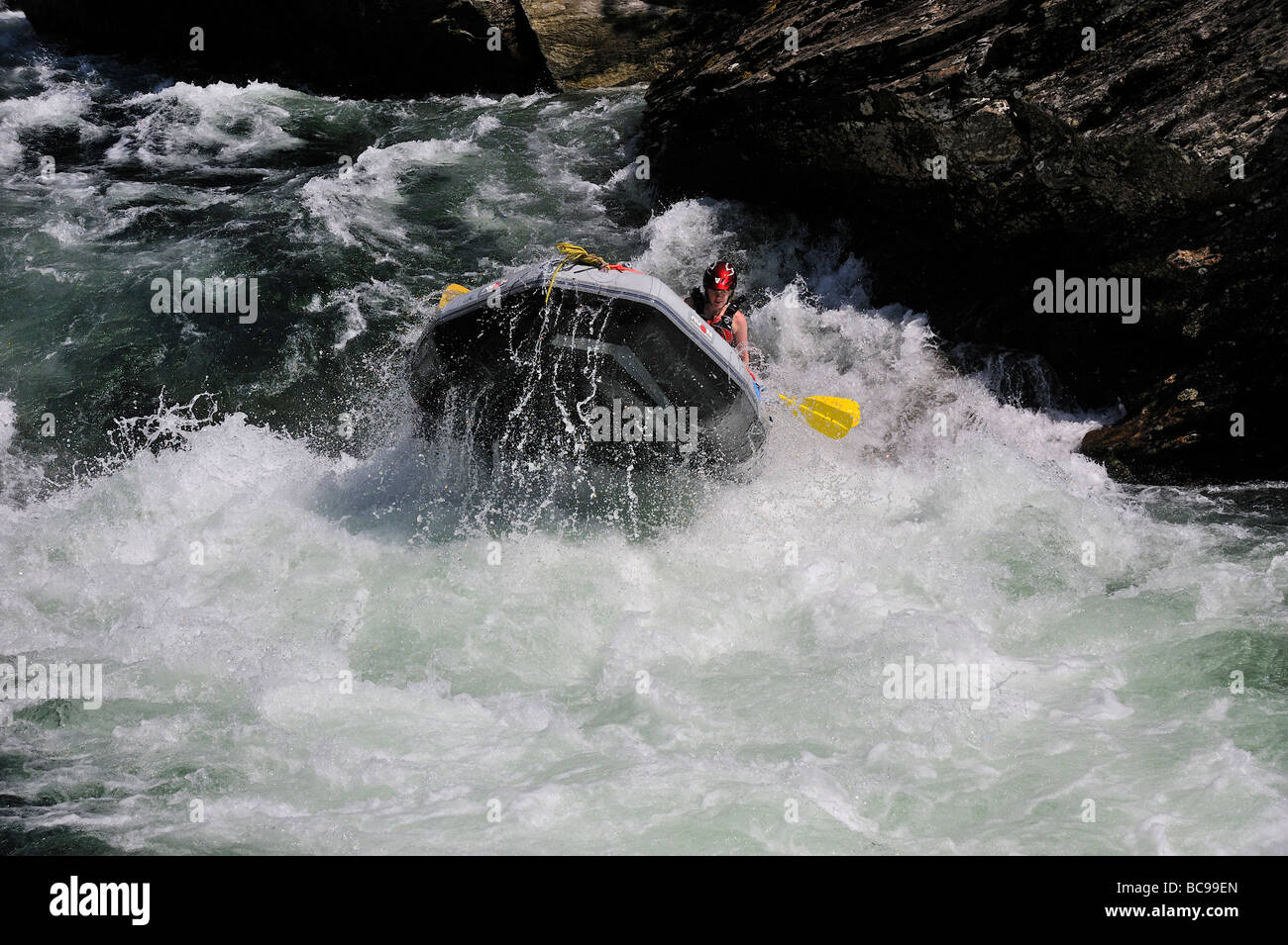 White water rafters steer their boat through rapids Stock Photo