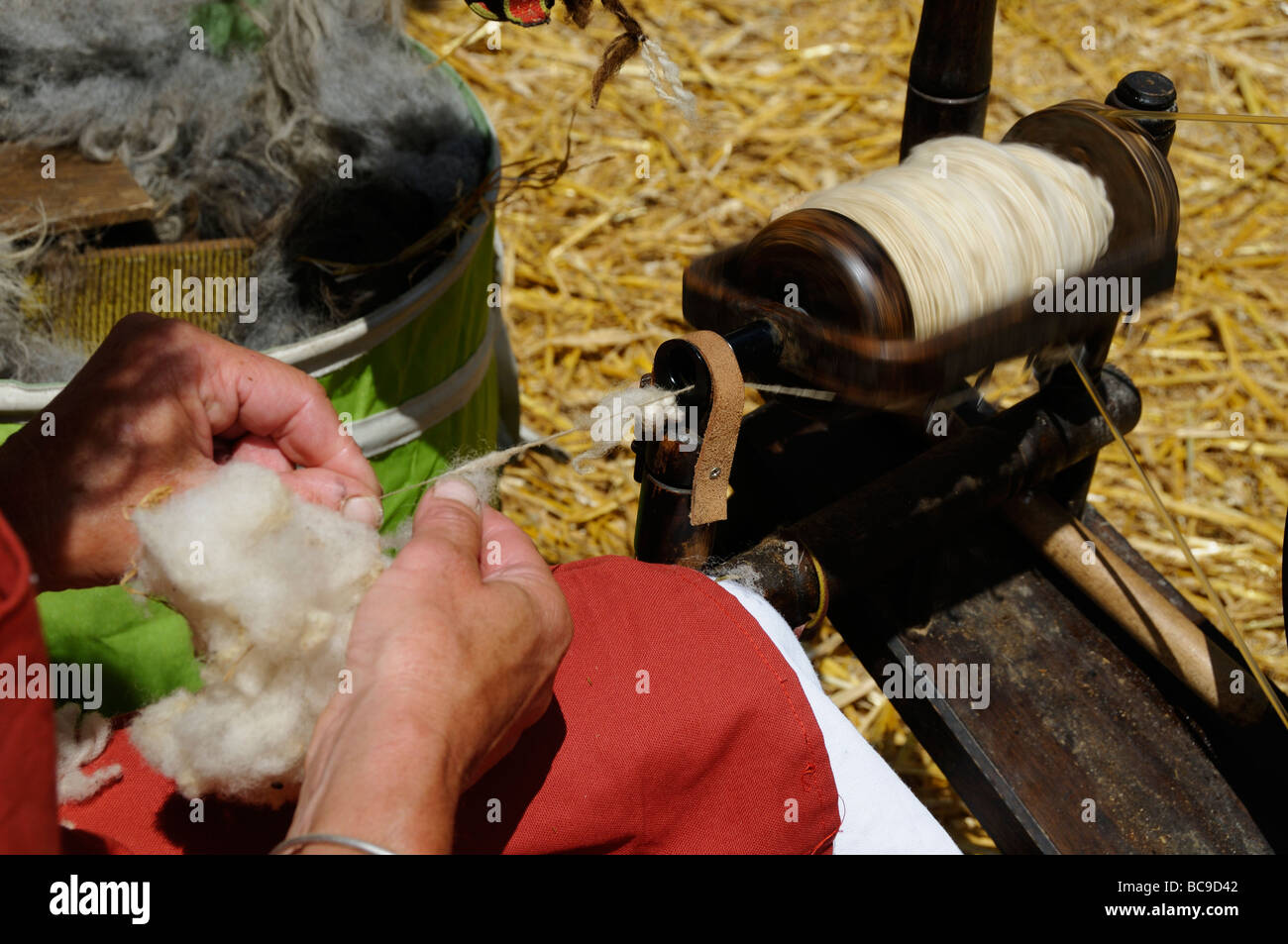 Stock photo of a woman spinning wool on her spinning wheel Stock Photo ...