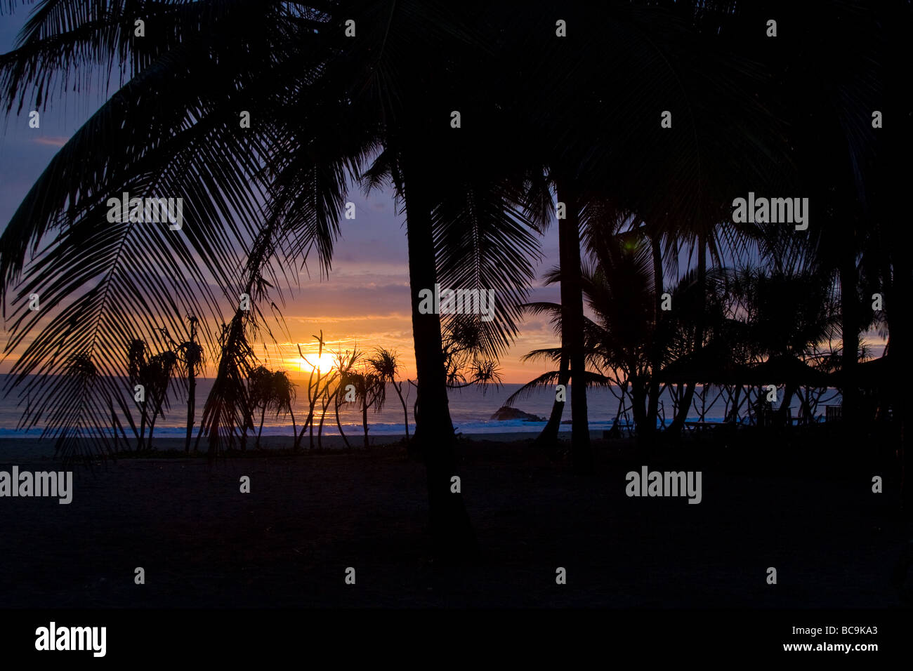 Sunset at Ngwe Saung beach in southern Myanmar with the silhouettes of ...