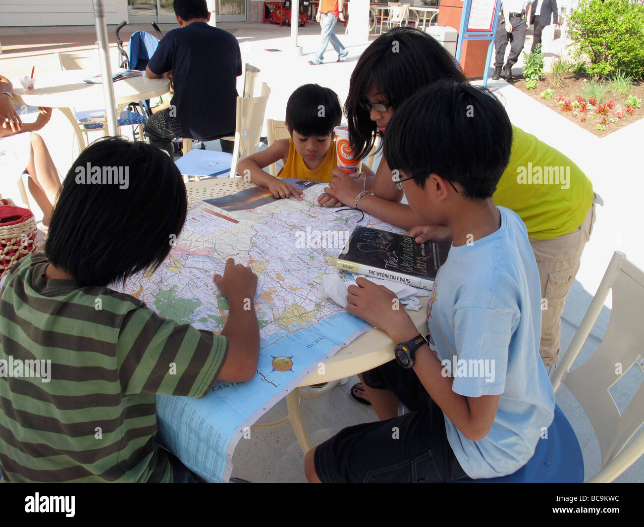 Asian brothers and sister looking at a map. Stock Photo