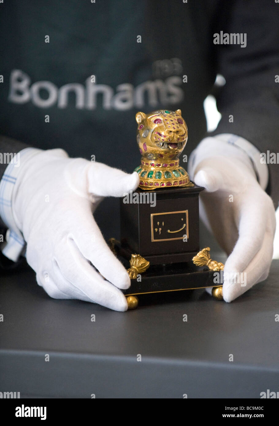 A Bonhams auction house employee holding a gem-encrusted gold finial from the octagonal golden throne of India's Tipu Sultan Stock Photo