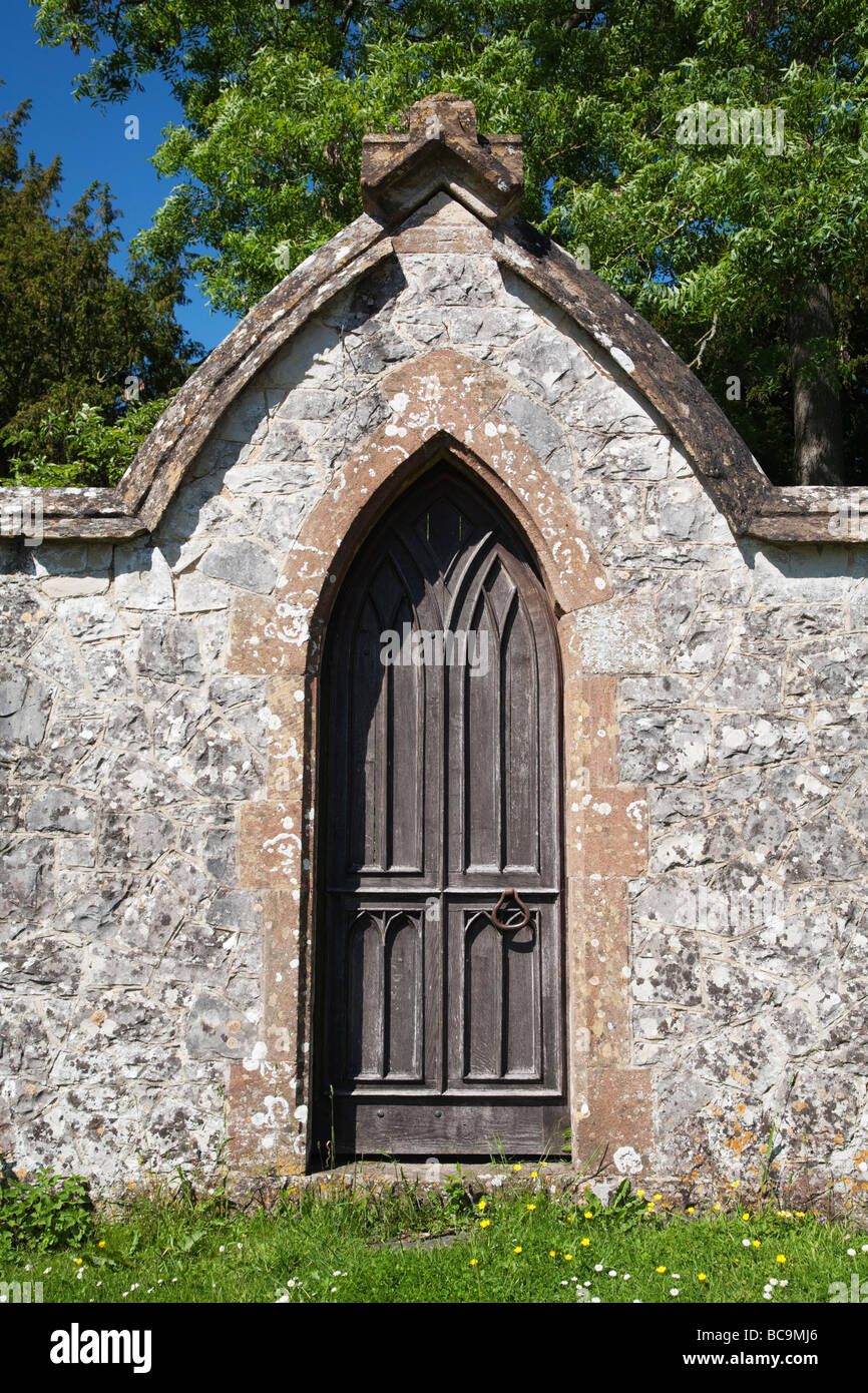 Graveyard entrance with old wooden door leading into stone walled ...