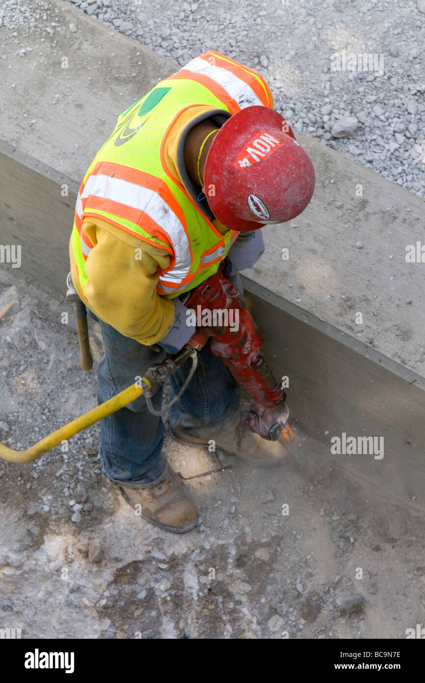 Construction worker using a jackhammer in downtown Chicago Illinois USA Stock Photo