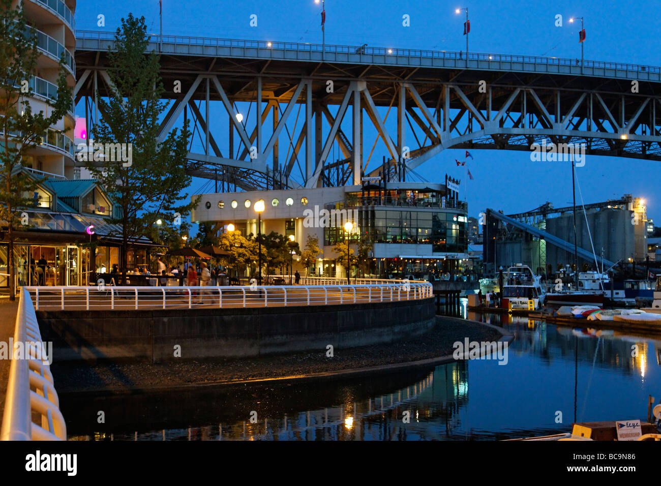 Promande and small Marina at False Creek at twilight Granville Bridge Vancouver Canada North America Stock Photo