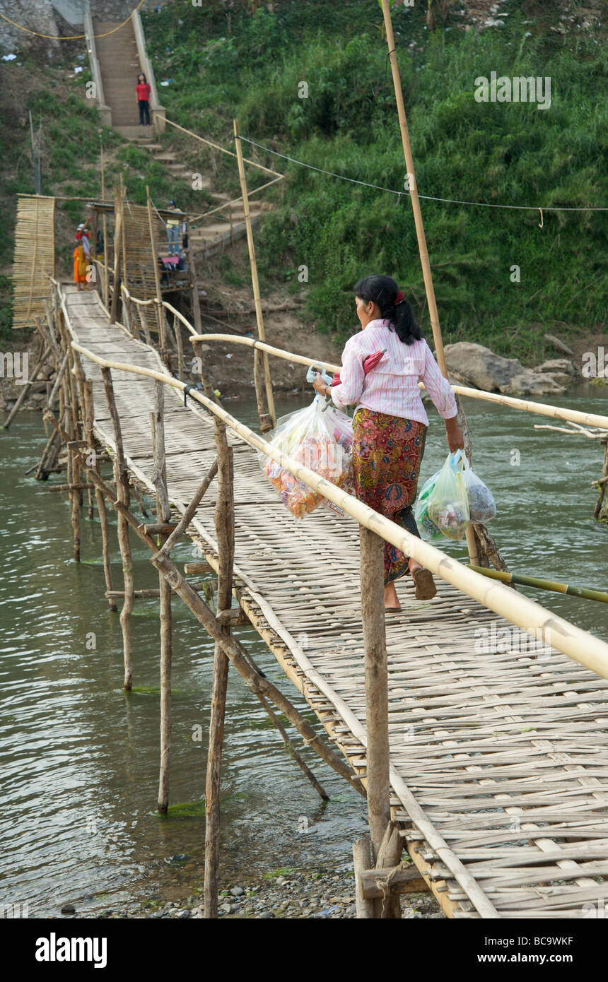 A Lao women crossing the bamboo bridge over the river Nam Khan in Luang Prabang Laos Stock Photo