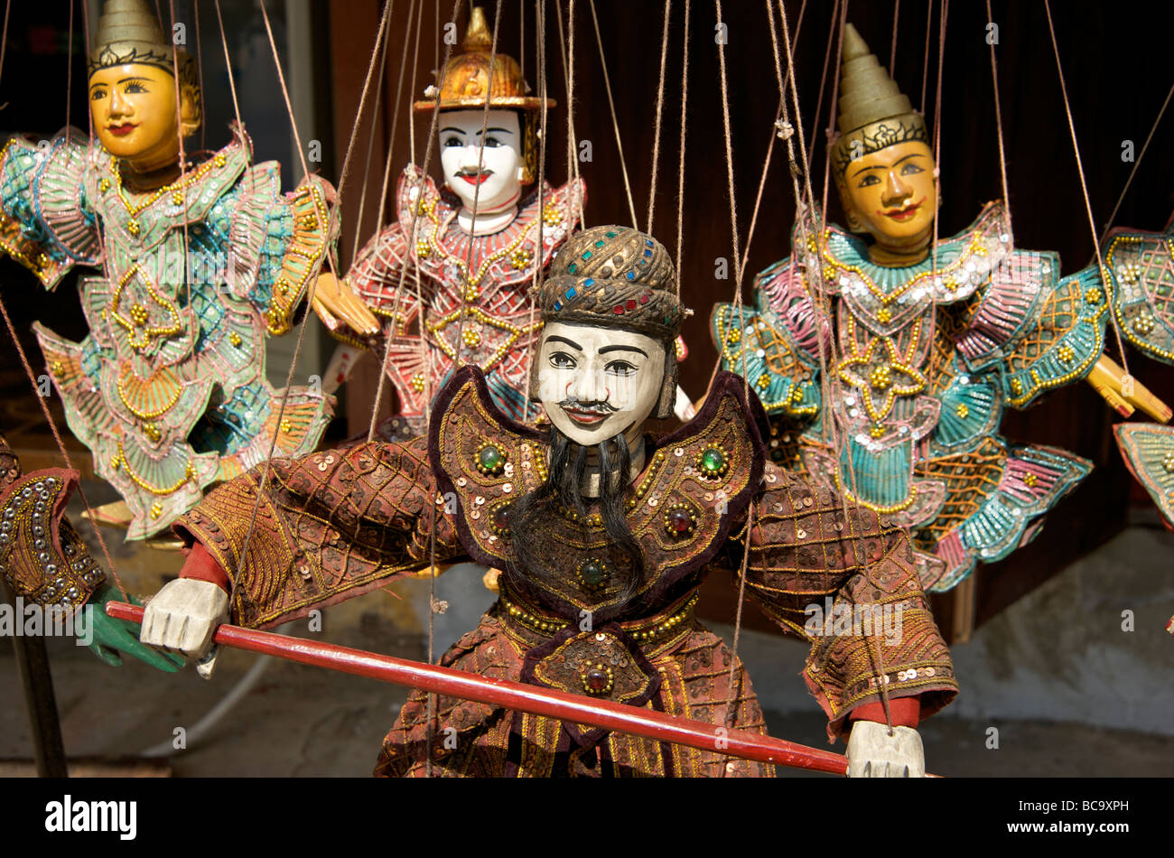 Four Traditional wooden Burmese marionettes hanging in a shop doorway Luang Prabang Laos Stock Photo