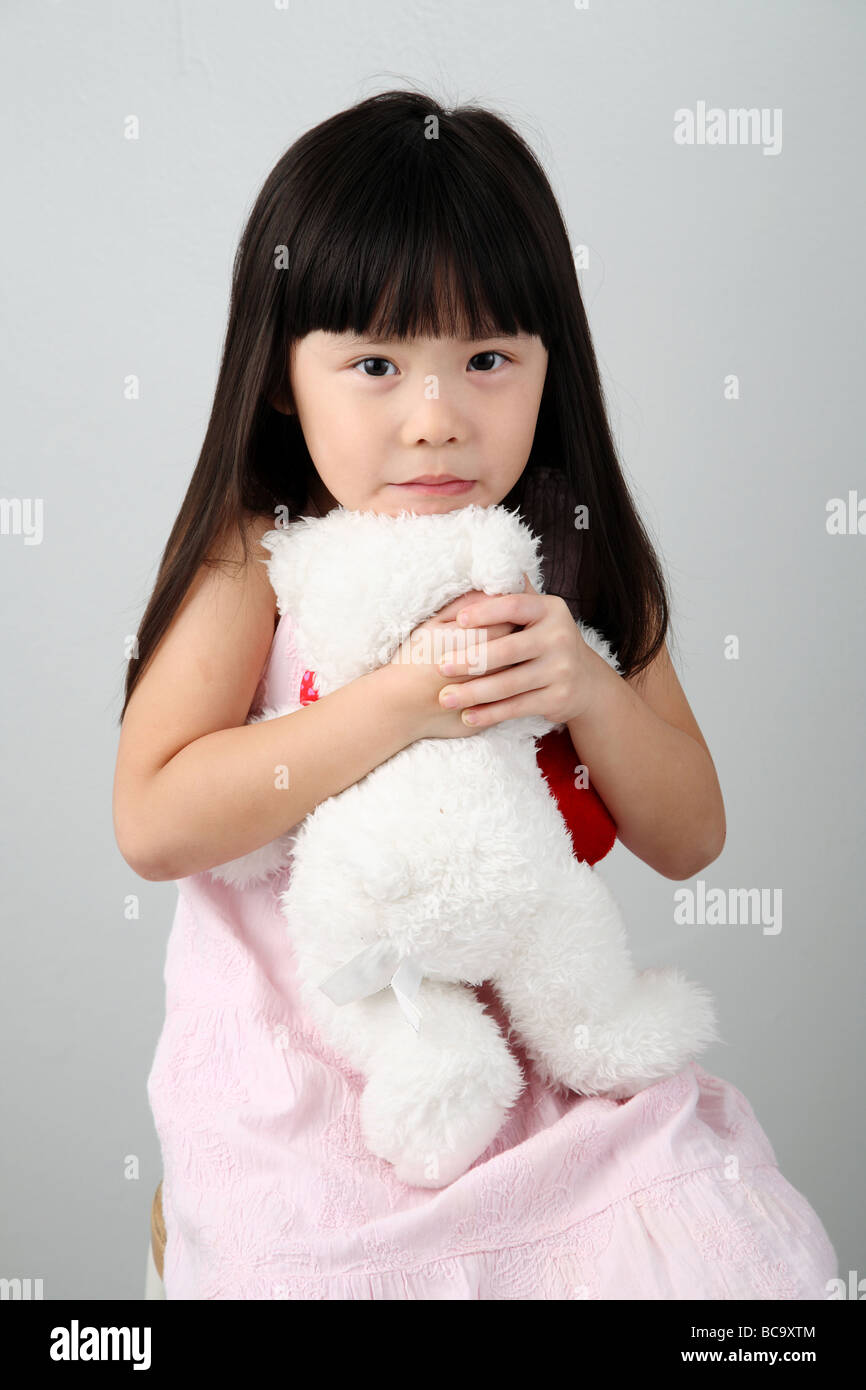 little chinese girl hugging a teddy bear Stock Photo - Alamy