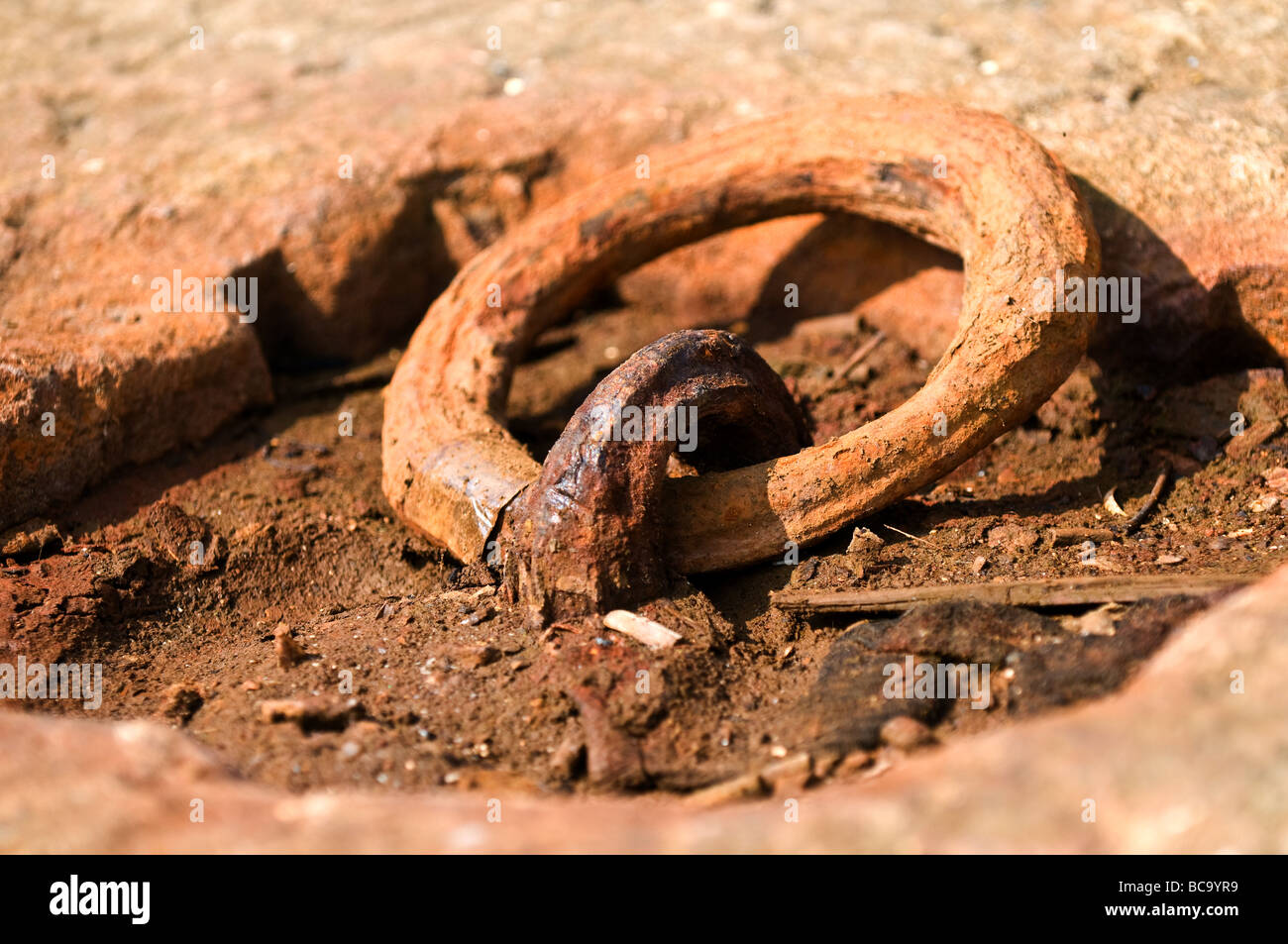 A closeup view of a rusty iron ring set in a granite block at Leigh on