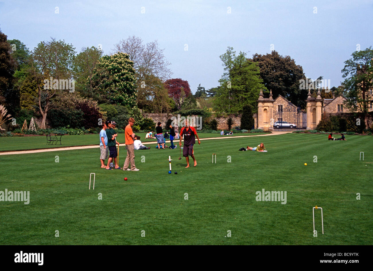 Students relaxing on the croquet lawn of Trinity College, Oxford, after the end of final exams England, UK Stock Photo