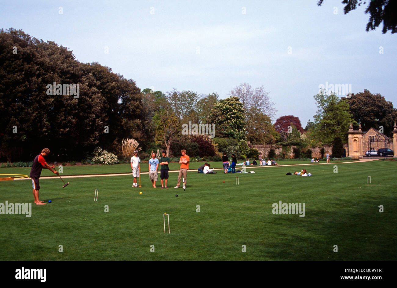 Students relaxing on the croquet lawn of Trinity College, Oxford, after the end of exams, England, UK Stock Photo