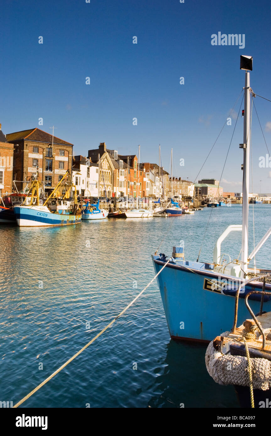 Morning sunlight on fishing boats moored in Weymouth Harbour Stock Photo
