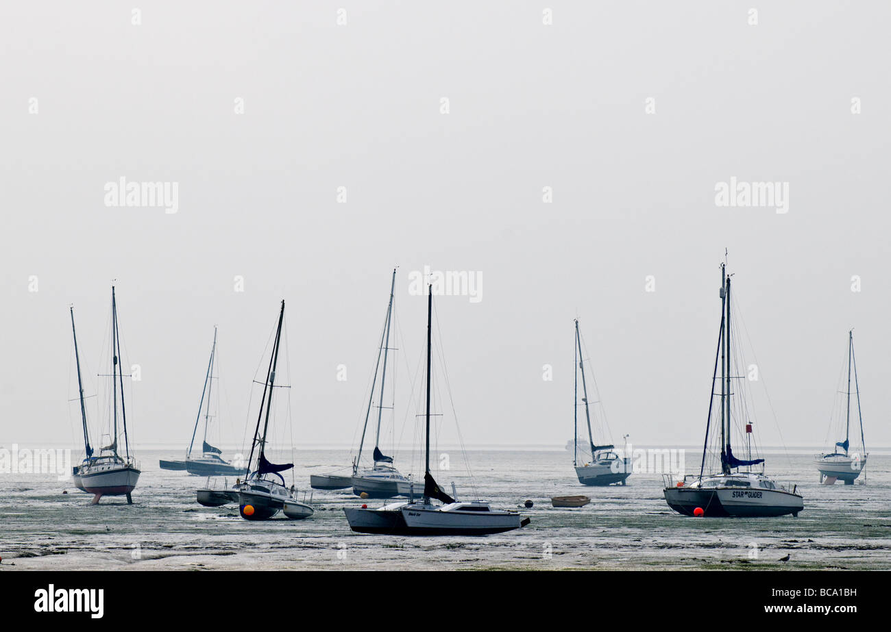 Boats beached on the mud at low tide near Leigh on Sea in Essex. Stock Photo