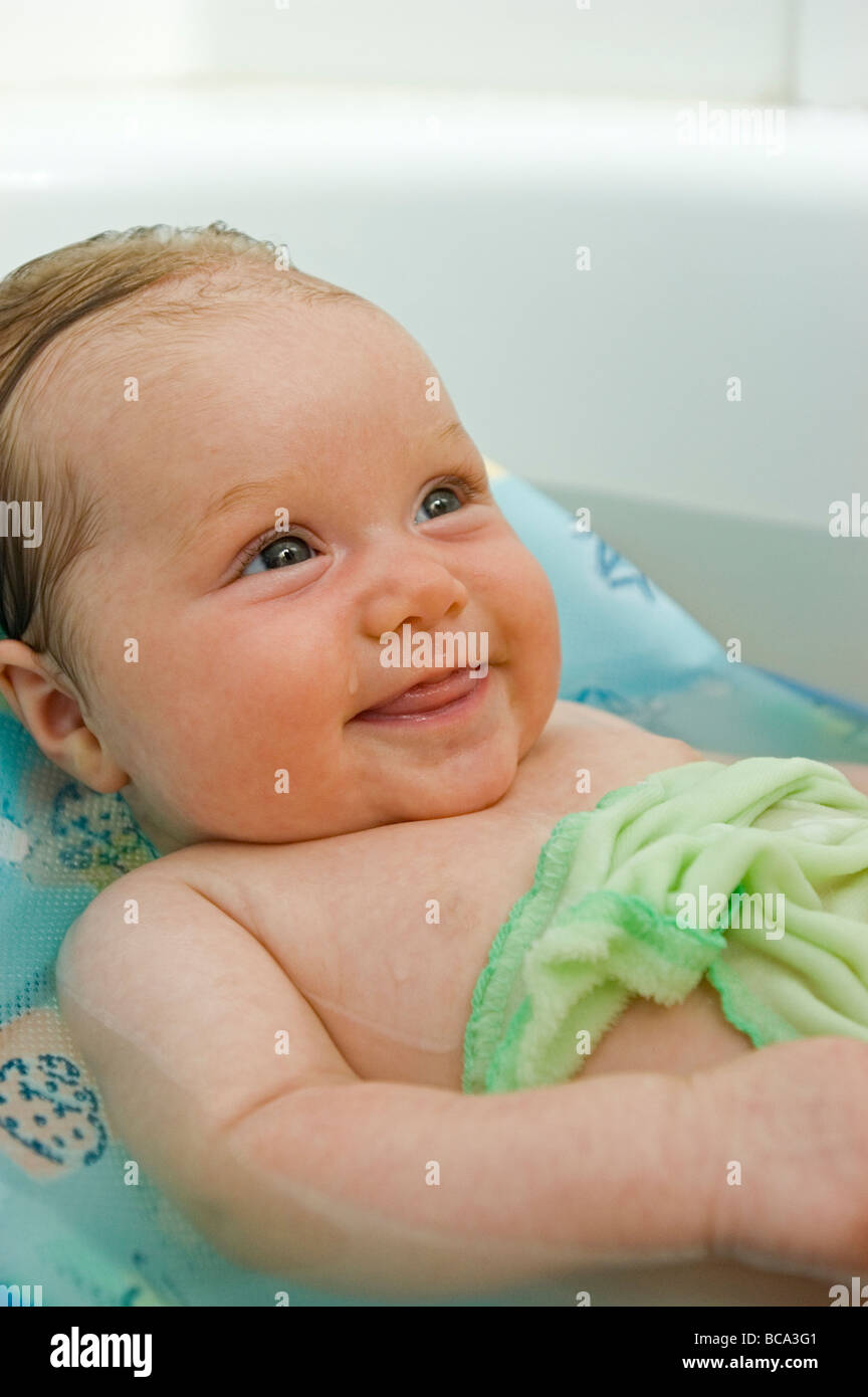 A 7week old baby girl smiles as she is given her bath Stock Photo Alamy