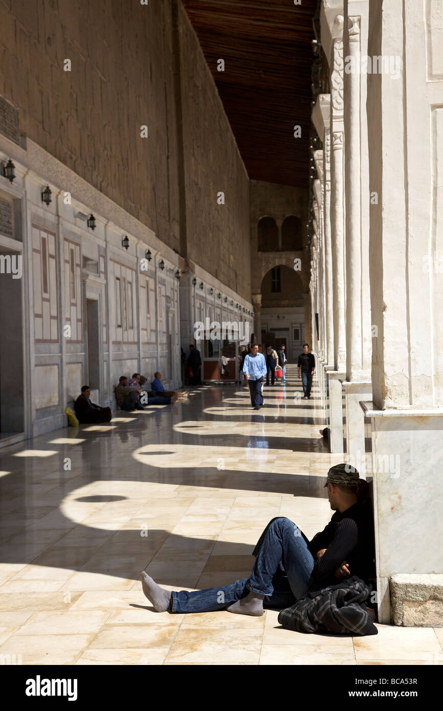 Tourists and visitors resting in the shade under arches at the Great Umayyad Mosque, Damascus, Syria Stock Photo