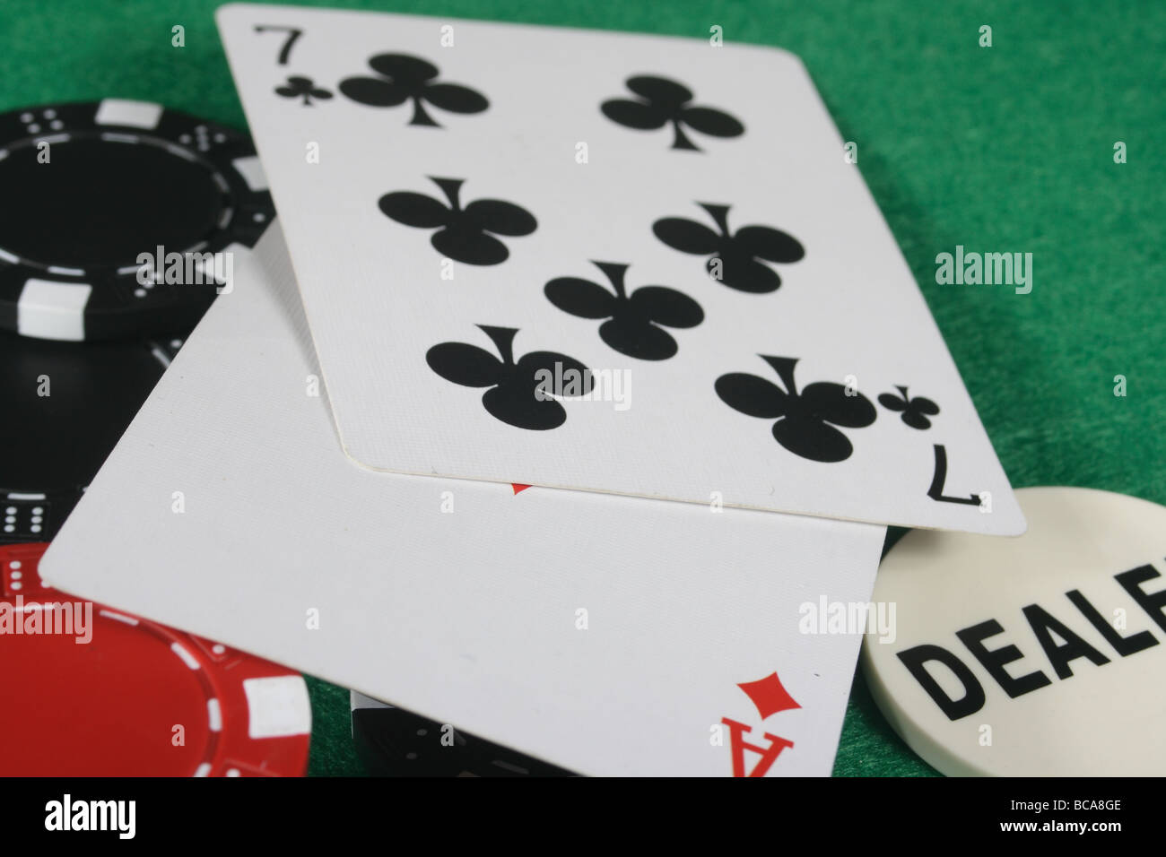 ace of diamonds and seven of clubs on a card table with red and black gambling chips. Stock Photo