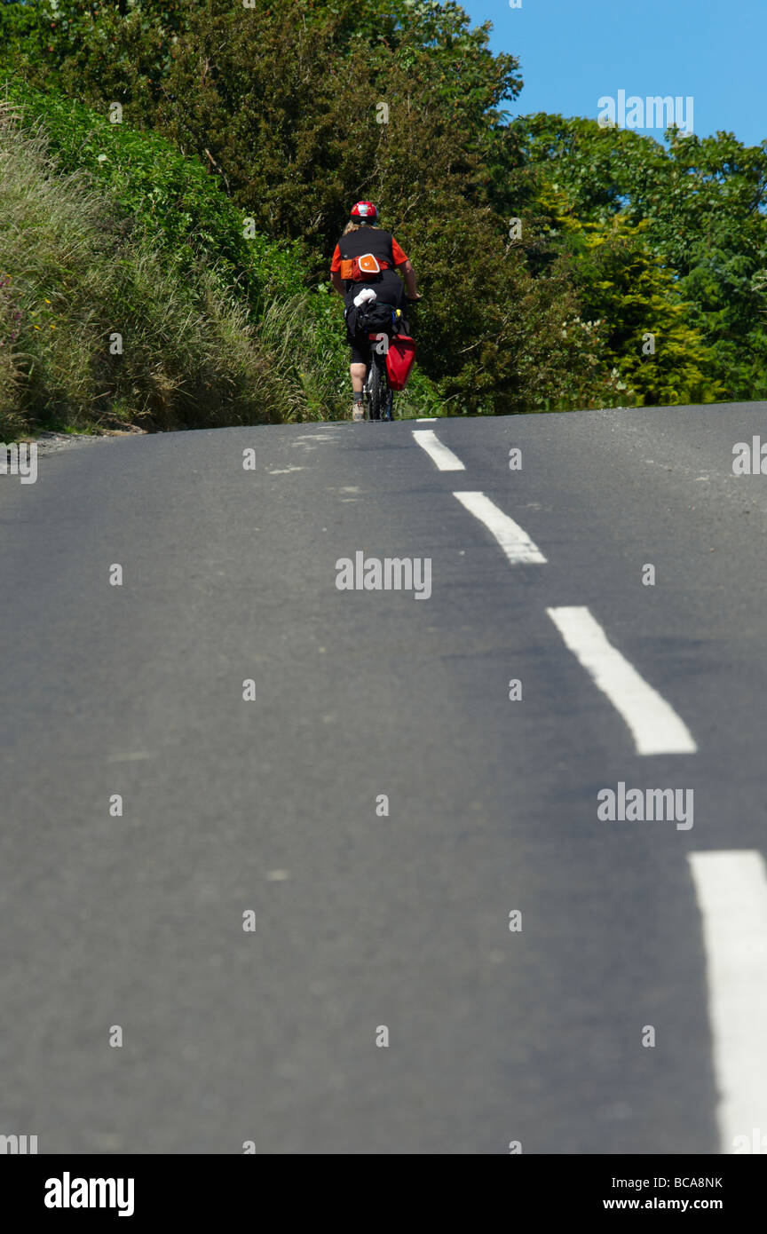 Touring cyclists climbing a hill on the Causeway Coastal route, Northern Ireland Stock Photo