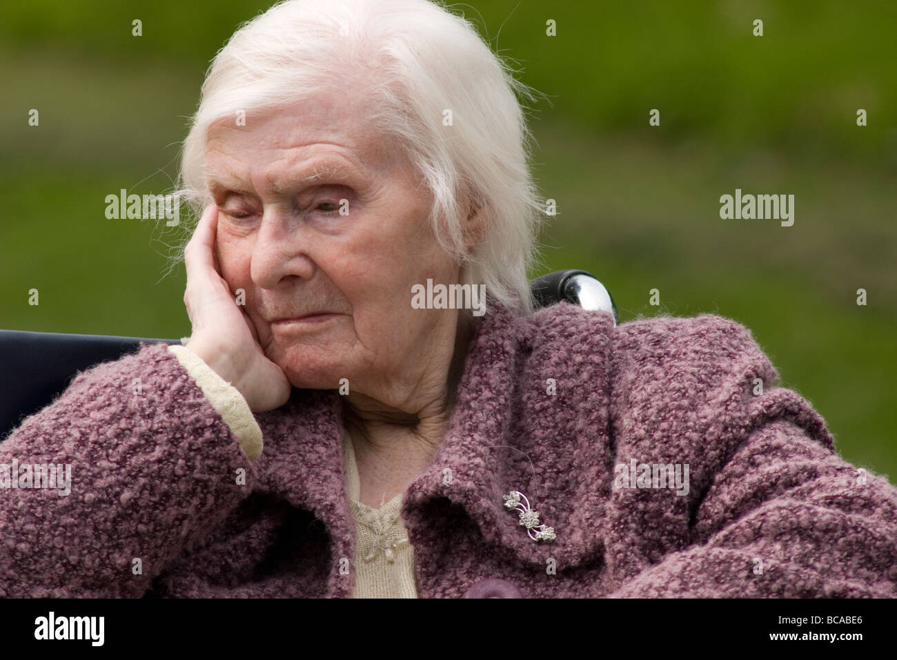 unhappy very old lady in wheelchair in park Stock Photo