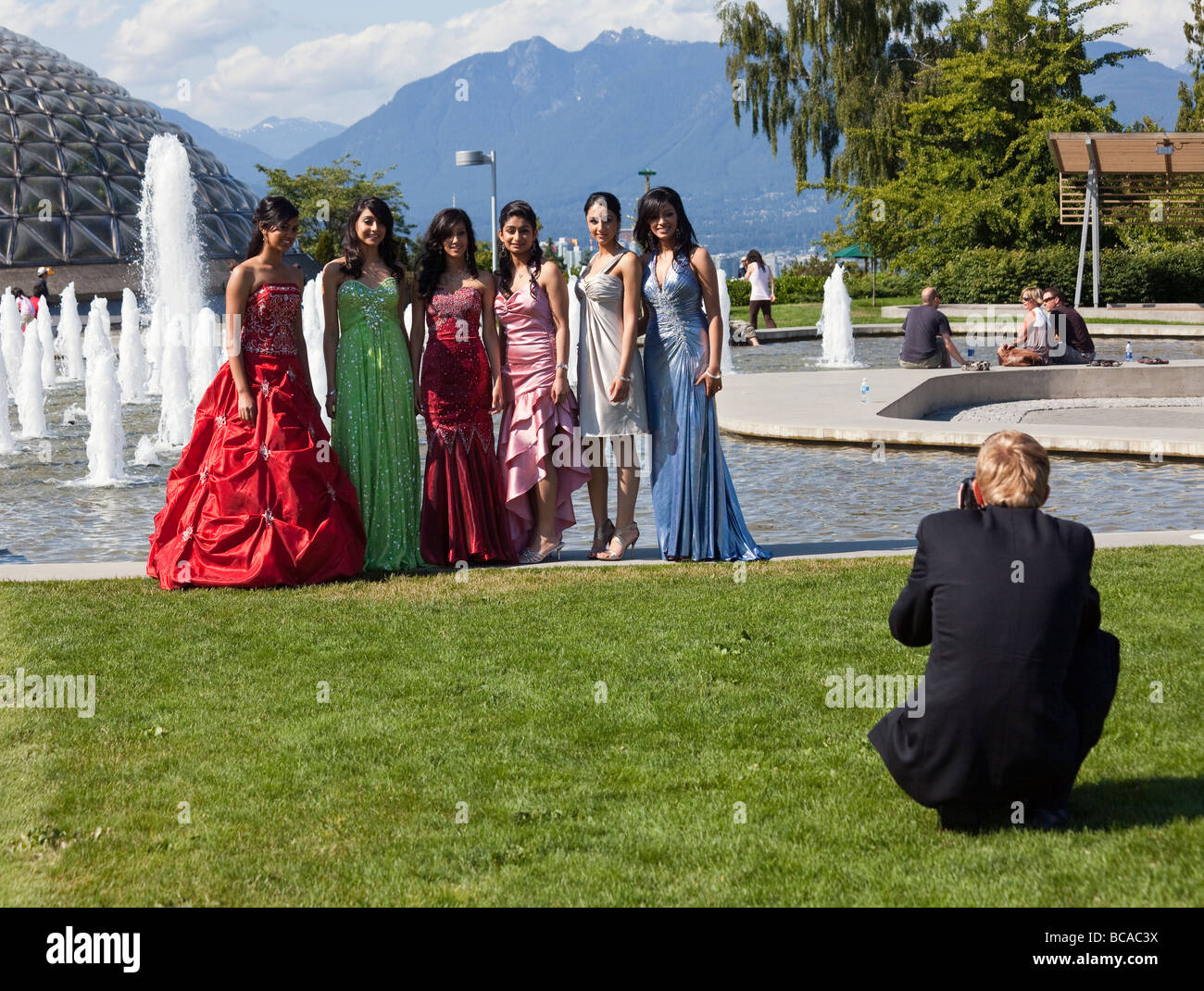 boy photographing girl students in formal dress for school prom at Queen Elizabeth Park, Vancouver, British Columbia, Canada Stock Photo