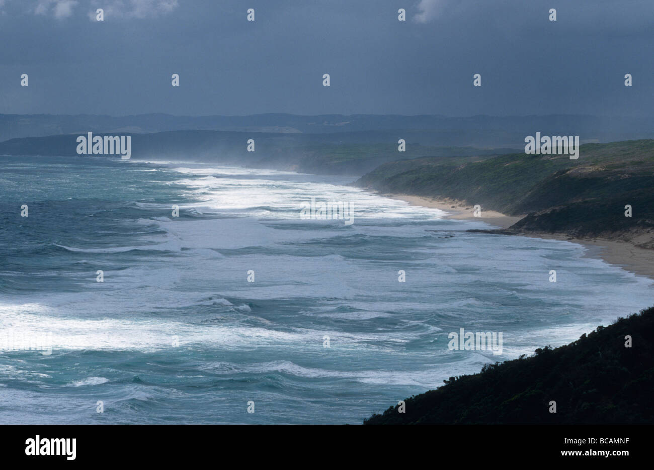 Storm waves create a salty mist flowing over ocean beach sand dunes. Stock Photo