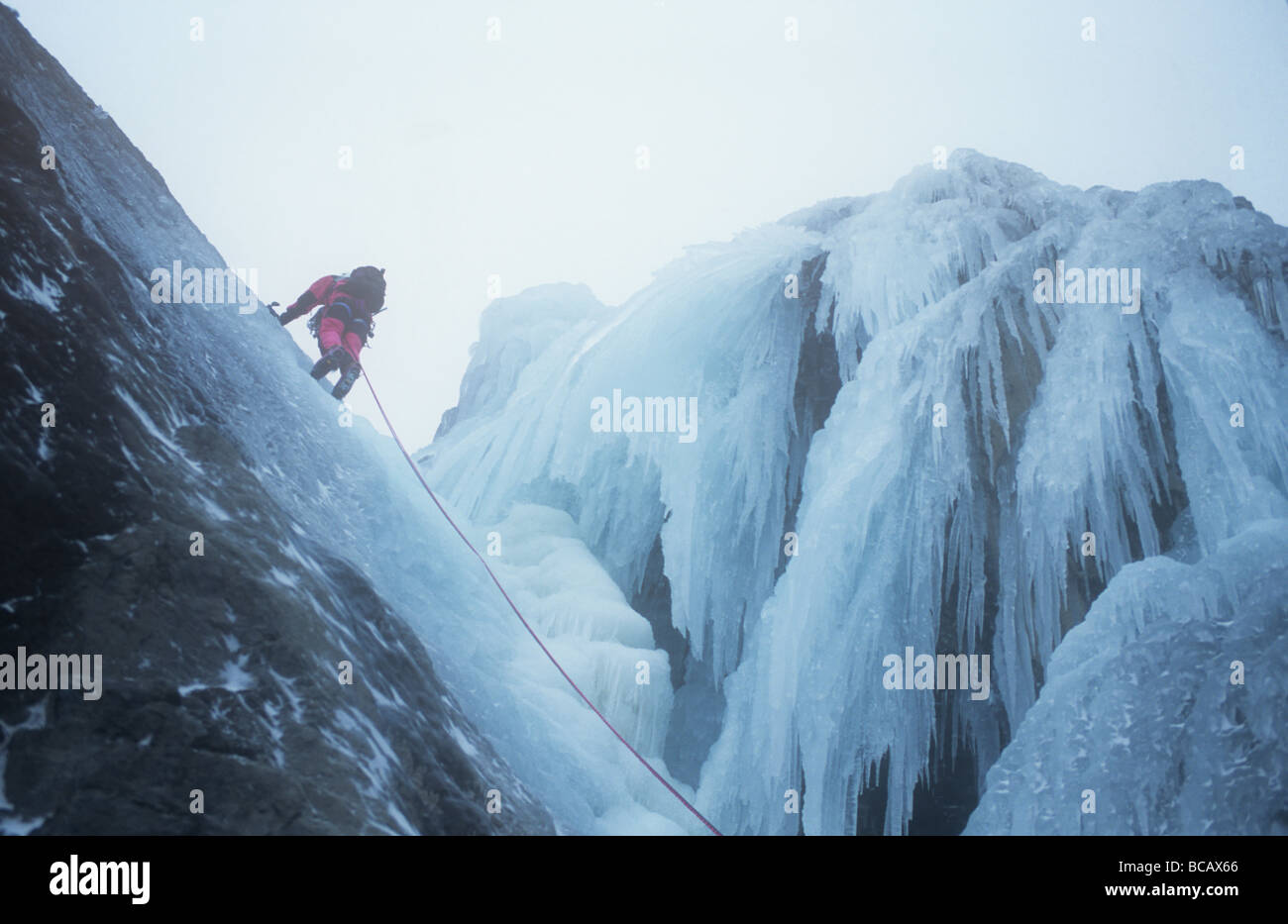 A mountaineer ice climbing on Low Water Beck Coniston Lake District UK