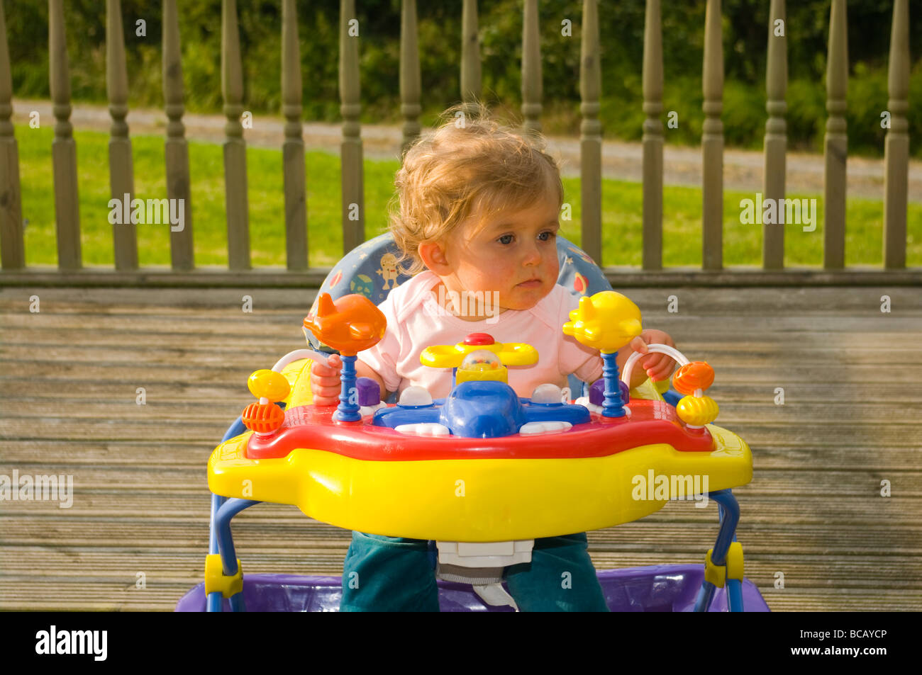 Young Baby Girl Seated In A Colourful Baby Walker Stock Photo Alamy