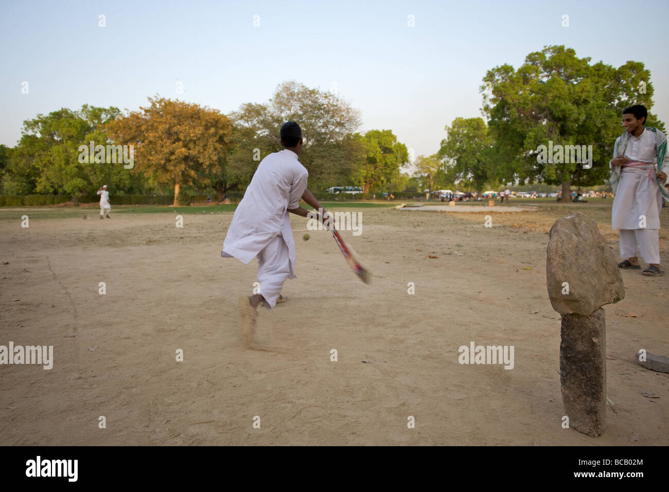 Boys playing cricket in a New Delhi park, India Stock Photo