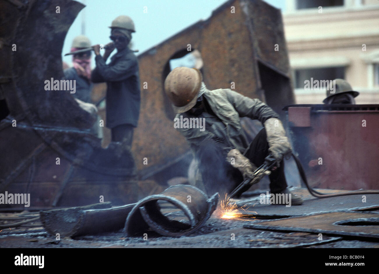 Sparks from a worker manually dismantling a rusted Super Tanker. Stock Photo