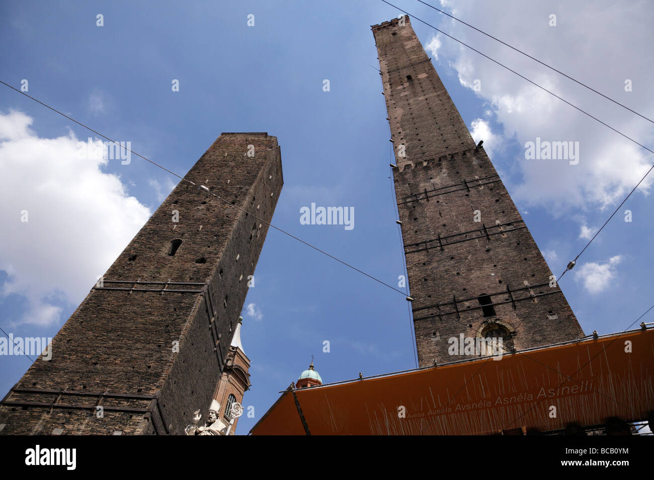 looking up at the two towers with the statue of st petronius by brunelli in piazza ravegnana bologna italy Stock Photo