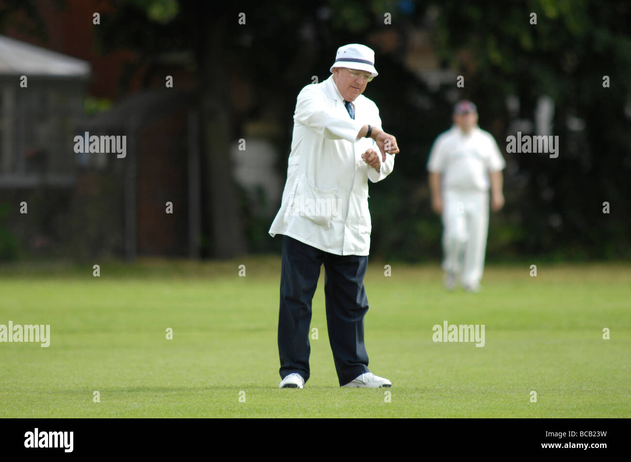 cricket umpire looks at his watch Stock Photo